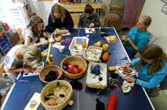 kids working at table on yarn paintings